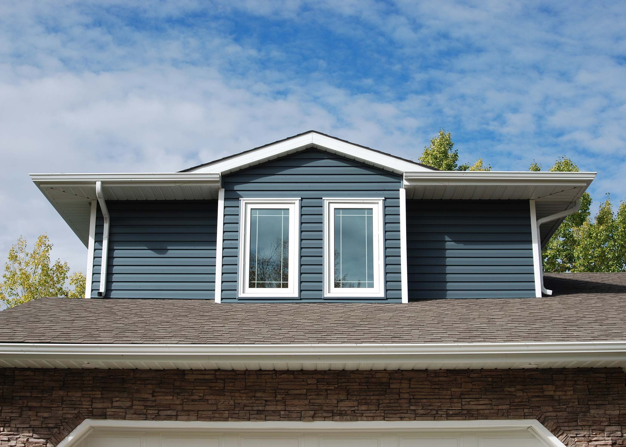 exterior shot of the second storey windows of a house with blue siding